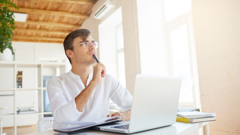 Youngman with laptop is thinking