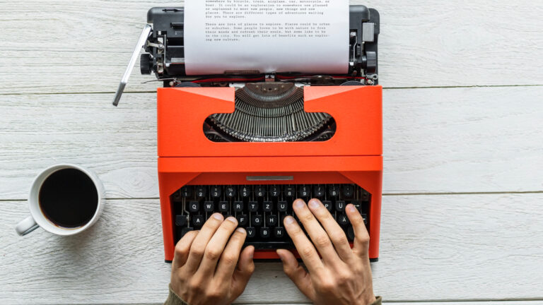 Man is typing on a retro typewriter